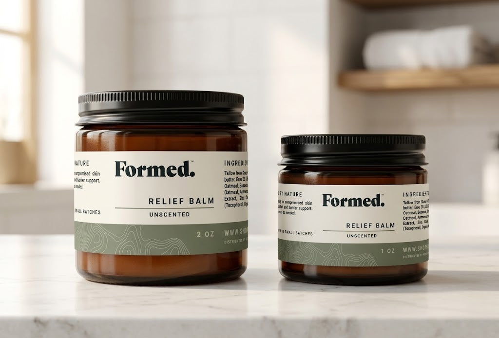 Two jars of Formed Relief Balm on a marble surface with a neutral background.